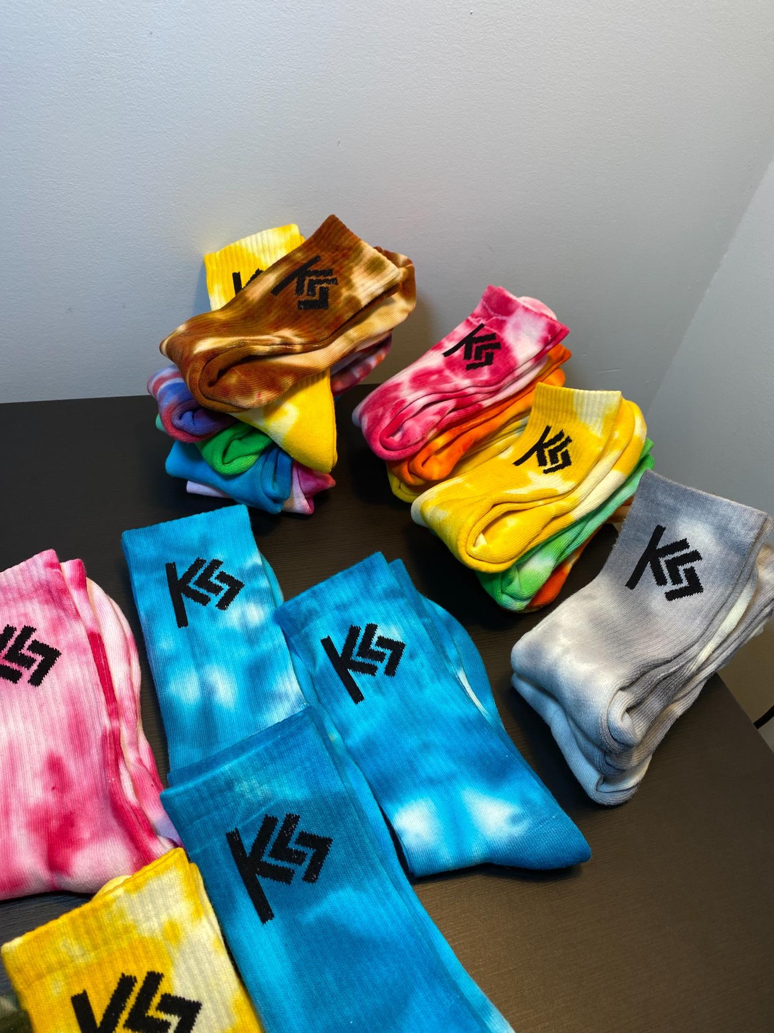 Colorful socks with a logo on a dark surface