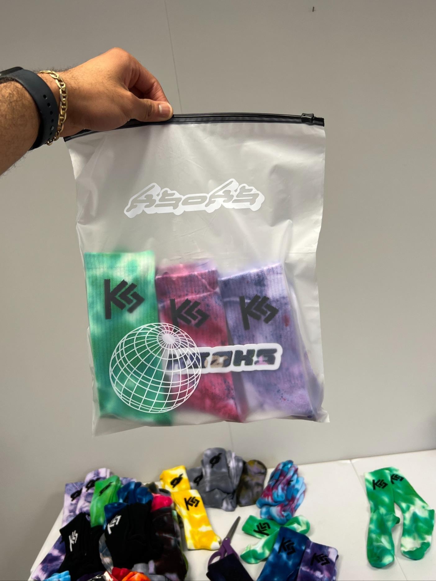 Clear bag with colorful socks and a visible brand logo on a plain background