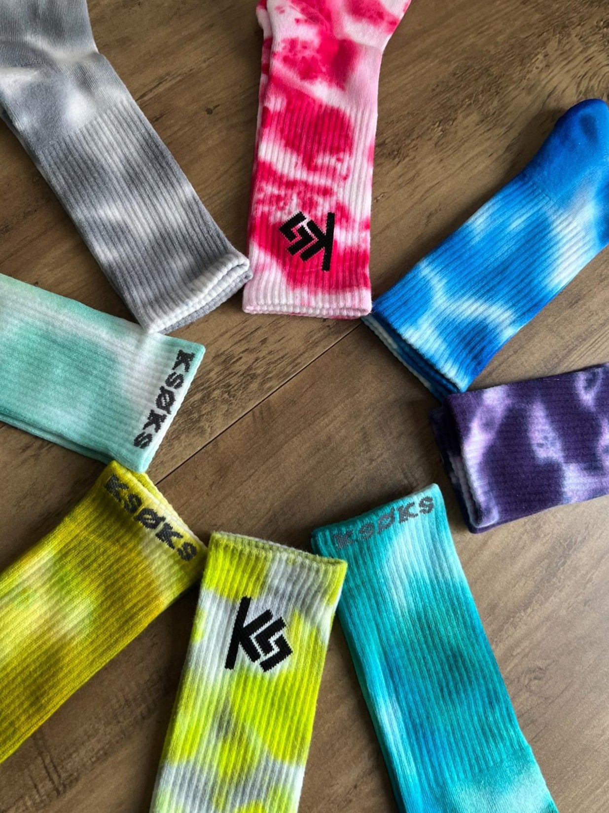 Colorful socks arranged in a circle on a wooden surface