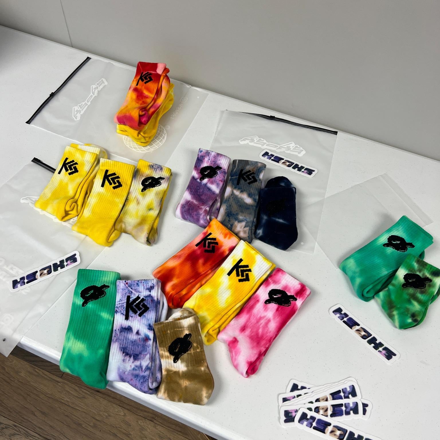Colorful socks displayed on a white surface with 'KSØKS' branding.
